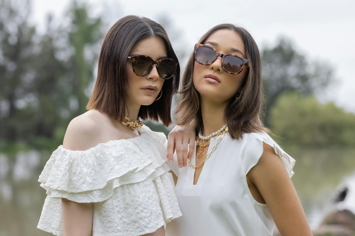 Dwie dziewczyny w okularach przeciwsłonecznych i naszyjnikach damskich